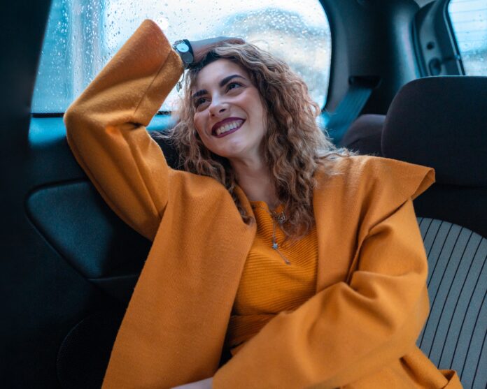 Women with Yellow Jacket Smiling in Car
